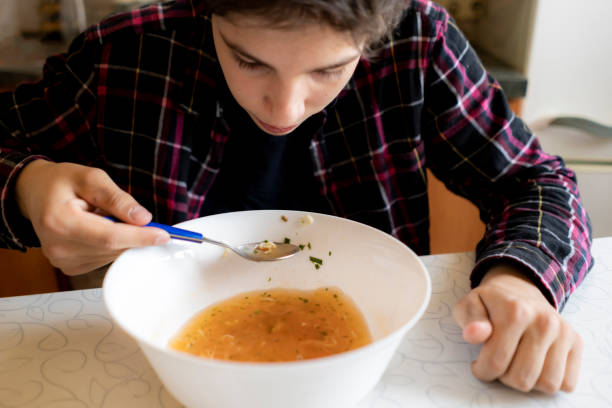 istock young man eat hot soup with noodles at the kitchen 1156726485