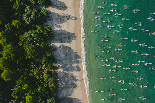 Scenic aerial view of a lot of fishing boats in lagoon on Java, Indonesia