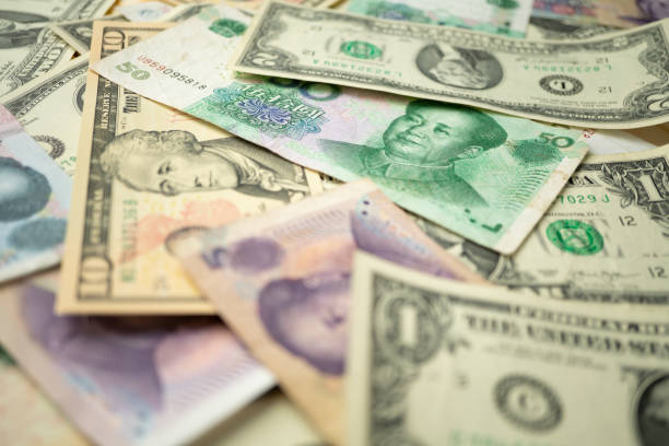 istock US dollar stack and Chinese yuan banknotes on the table The concept of a trade war between the United States and China 1156728587