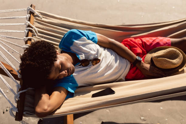 istock Man sleeping in a hammock on the beach 1156728627