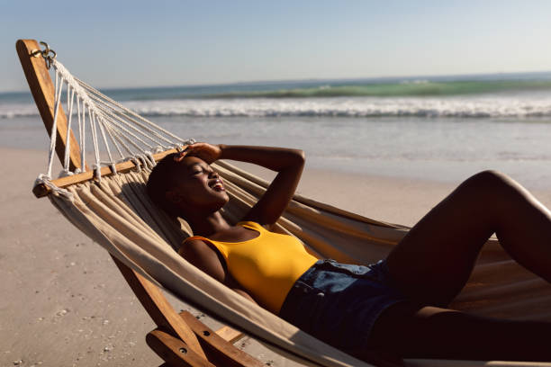 istock Woman relaxing in a hammock on the beach 1156730201