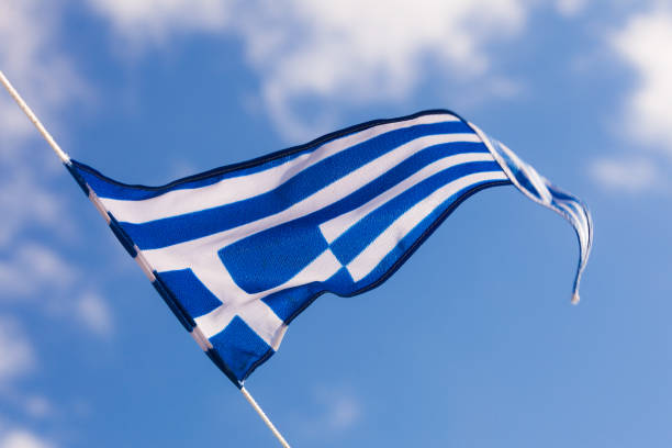istock Greek flag waving against blue sky 1156730244