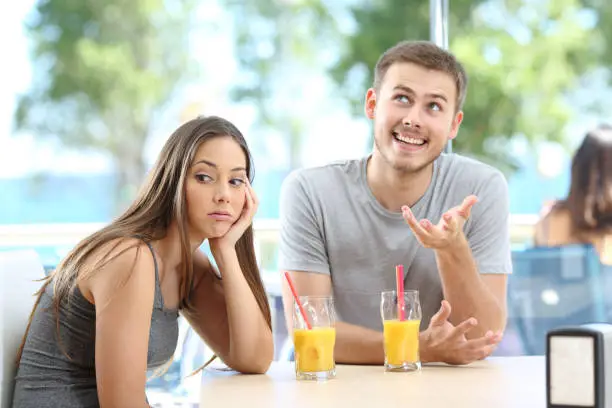 Photo of Bored girl listening a bad conversation from a friend or partner