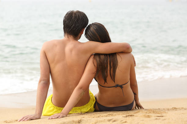 istock Couple hugging looking at ocean on the beach 1156732203