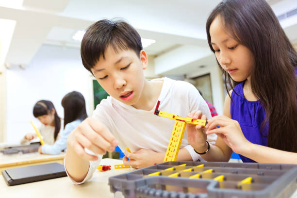 istock Students building robot at desk in STEM classroom 1156732885