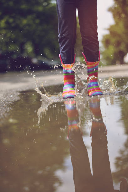 istock Child's feet in rubber boots. Summer, puddles, rain 1156733108