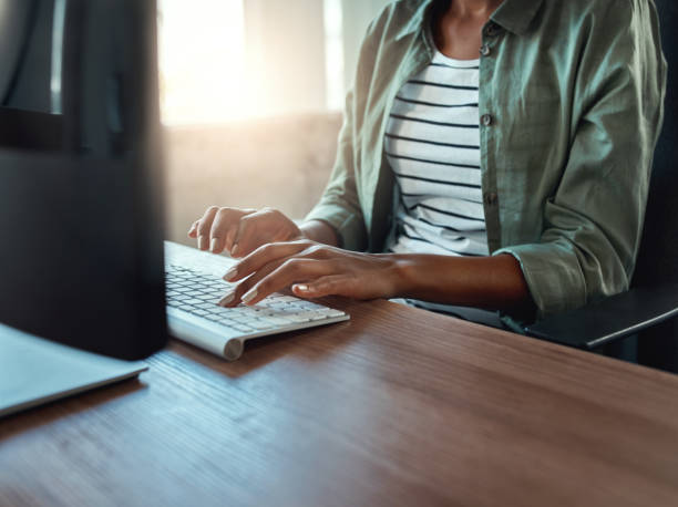 femme d'affaires tapant sur le clavier à l'intérieur dans un bâtiment moderne - clothing casual concepts concentration photos et images de collection