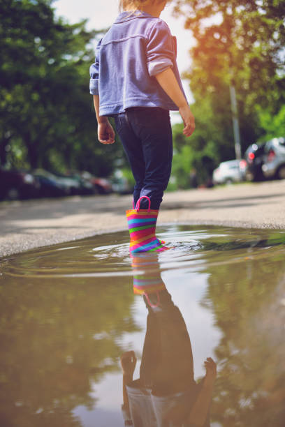 istock Child's feet in rubber boots. Summer, puddles, rain 1156733170