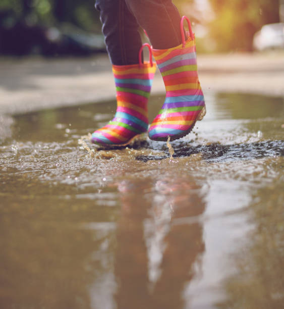 istock Child's feet in rubber boots. Summer, puddles, rain 1156733299