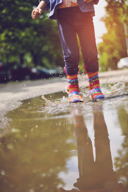 istock Child's feet in rubber boots. Summer, puddles, rain 1156733540