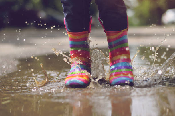 istock Child's feet in rubber boots. Summer, puddles, rain 1156733582