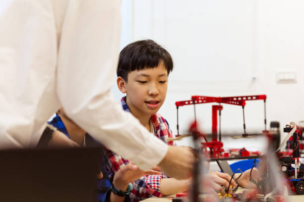 istock Teacher with male students holding science project 1156736670