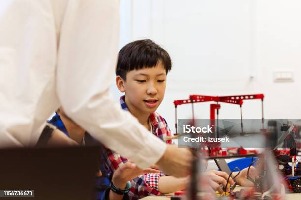Teacher With Male Students Holding Science Project Stock Photo - Download Image Now - 10-11 Years, 50-54 Years, Adult