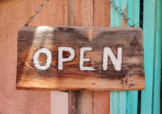 istock Open text on wooden sign board on a buildings entrance 1156739617