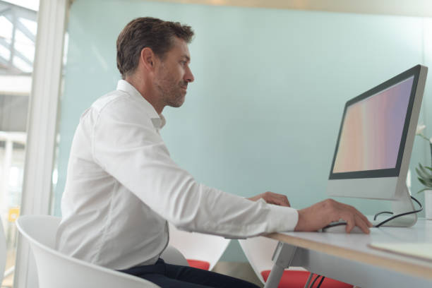 istock Business male executive working on computer at desk in a modern office 1156740684