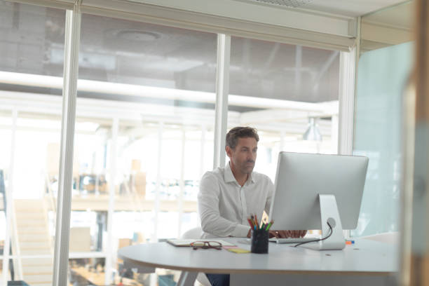 istock Business executive working on computer at desk in a modern office 1156741380