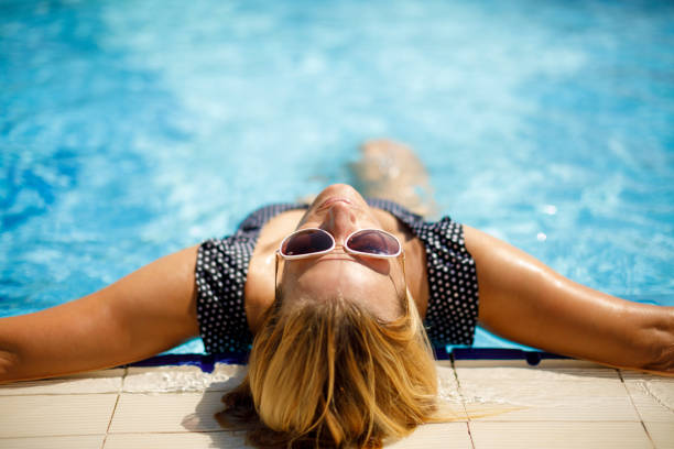 istock Woman relaxing in swimming pool 1156742272