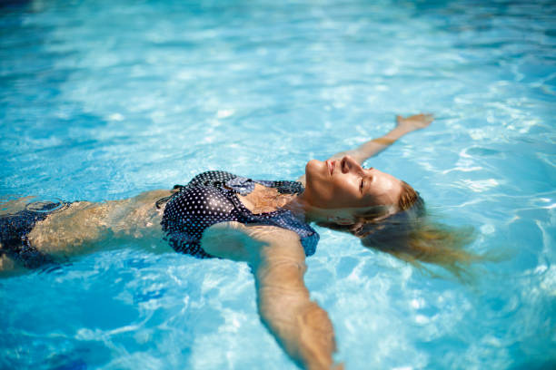 istock Woman relaxing in swimming pool 1156742343