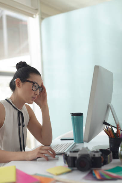 istock Female graphic designer working on computer at desk in a modern office 1156743097