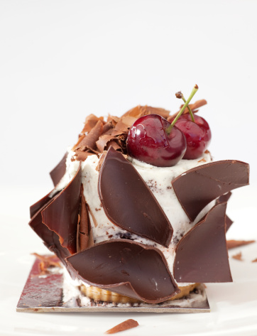 ice cream cake with pieces of chocolate and cherries on top