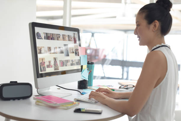 istock Female graphic designer working on computer at desk in a modern office 1156747489