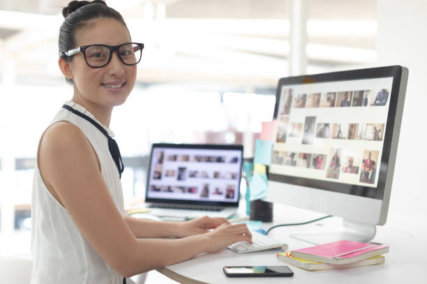 istock Female graphic designer looking at camera while working on computer at desk 1156747908