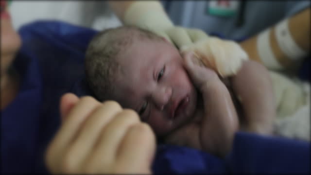 Newborn baby birth first seconds of infant baby life
