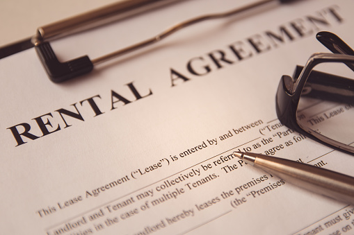 Concepto de documento legal empresarial : Pluma y gafas en un formulario de contrato de alquiler. photo