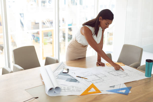 istock Female architecture working on blueprint on table in a modern office 1156751225