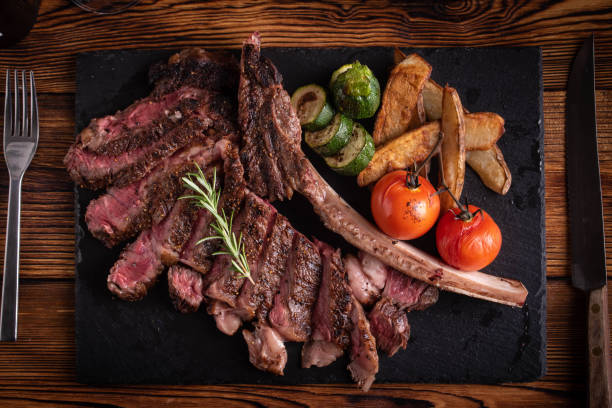 istock grilled tomahawk ribeye steak on black stone plate 1156755054