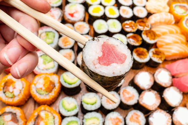 istock chopsticks with tuna roll over various of sushi 1156757555