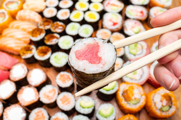 istock chopsticks with tuna roll over set of sushi 1156757557