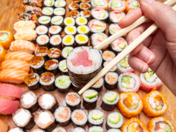 istock chopsticks with tuna roll over assortment of sushi 1156757569