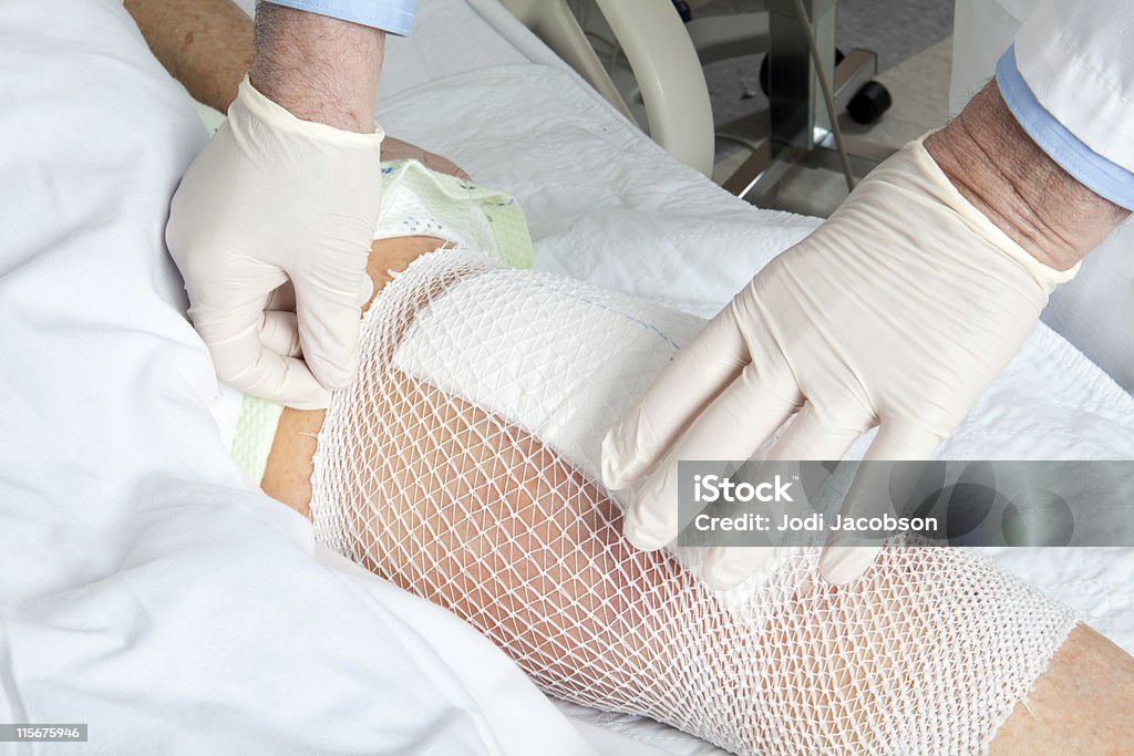Mesh holds a knee replacement bandage in place. - 免版稅傷口圖庫照片