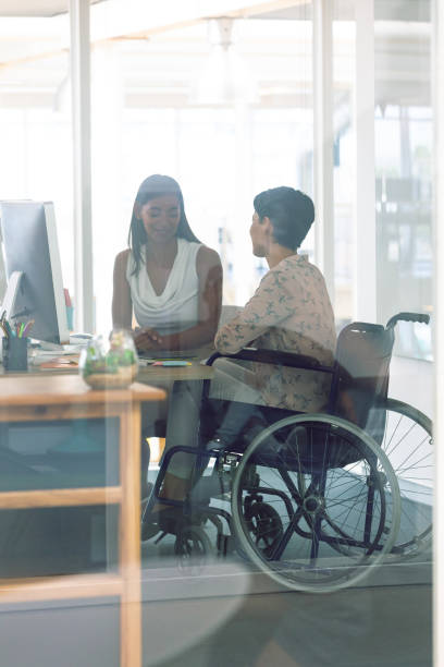 istock Female graphic designers interacting with each other at desk in a modern office 1156760582
