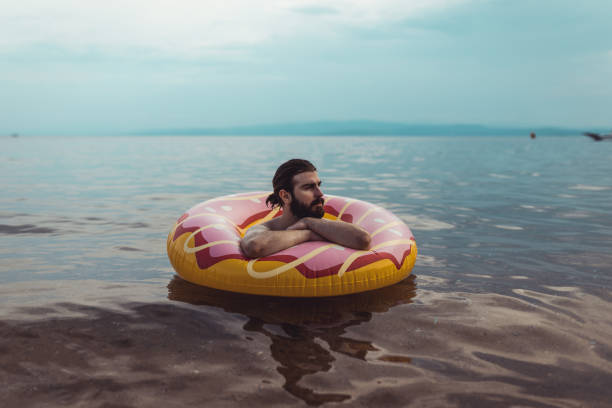 istock Man with an inflatable ring at the seaside 1156760738