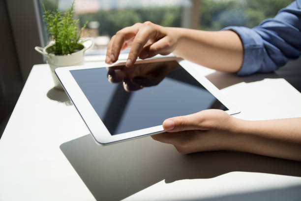 istock Woman holding tablet with blank empty screen 1156760760