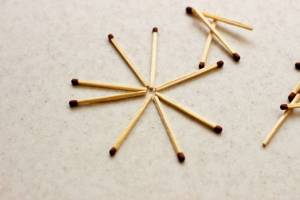 istock Matches scattered around on a table - concept of security. Unused matches on white surface. Matches the shape of the sun. Used matches. Used matches on white surface 1156762264