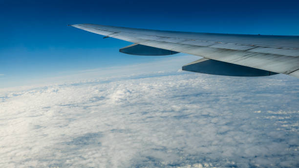 istock Close up of window with airplane wing. Beautiful cloudscape with clear blue sky. 1156764483