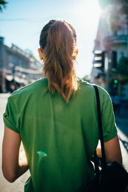 vista posteriore giovane donna che cammina - ponytail brown hair tourist women foto e immagini stock
