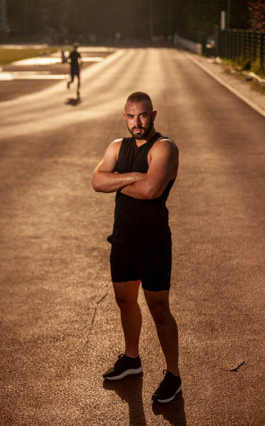 istock one young man, powerful athlete posing, looking to camera. 1156773083