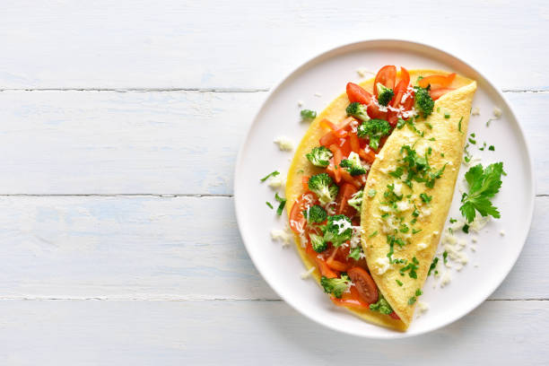 Stuffed omelette with tomatoes, red bell pepper and broccoli stock photo