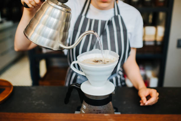 istock Female barista brewing coffee 1156775465