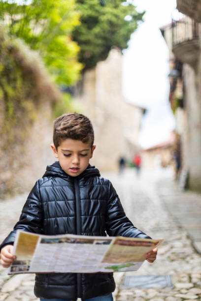 istock Little kid looking a map in the city 1156776637