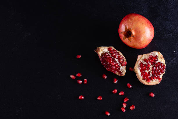 istock Red juice pomegranate on dark background 1156777603