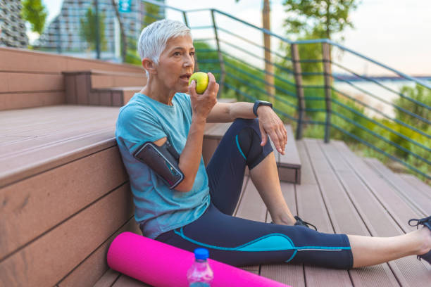 istock Senior woman with apple and water. 1156778119