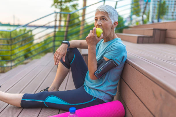 istock Senior woman with apple and water. 1156778131