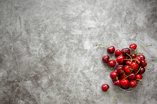 Background image , marble countertop and cherry berries . Summer season,harvesting berries ,jam,compotes.Space for labelling and advertising