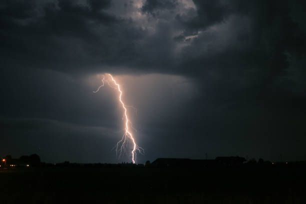 istock Bright branched lightning strike near an electricity mast from a severe thunderstorm in Holland 1156781634