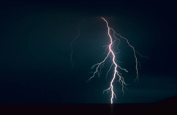istock Powerful bolt of lightning with many side branches strikes down in a lake 1156782419